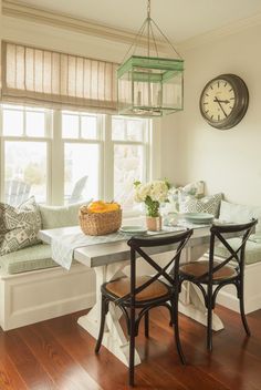 a living room filled with furniture and a clock hanging on the wall over a window