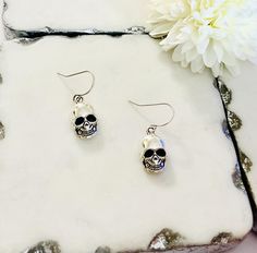 Check out these fabulous skeleton face earrings. The earrings are made from alloy metal. The earrings are approximately 1 inch long. The earring hooks are antique silver plated brass. All products are lead, cadmium free, and nickel safe. Thanks for stopping by! This listing is in compliance with Etsy policies. Nickel-free Skull Earrings In Punk Style, Nickel Free Metal Skull Earrings, Gothic Skull Metal Earrings, Skull Shaped Metal Earrings For Gifts, Skull-shaped Metal Earrings With Ear Wire, Metal Skull Earrings With Ear Wire, Metal Skull Single Earring, Silver Skull Earrings For Halloween, Silver Skull Earrings For Pierced Ears