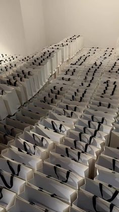 a room filled with lots of white boxes and black ribbons on the sides of them