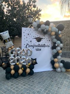 balloons and decorations are on display at a graduation party in front of a sign that says congratulations