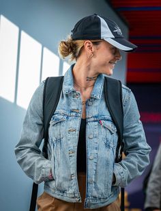 a woman wearing a denim jacket and hat