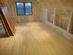 an empty room with wooden floors and windows