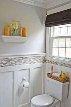 a white toilet sitting in a bathroom next to a window with yellow flowers on it