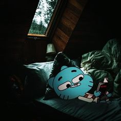 a blue pillow sitting on top of a bed next to a window in a dark room