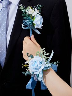 a man and woman wearing boutonnieres with blue flowers on their lapels