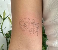 a woman's arm with two hearts and a dog paw tattoo on the wrist