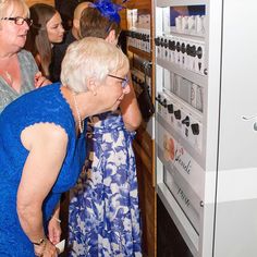 two women looking at items on display in a store while another woman watches from the other side