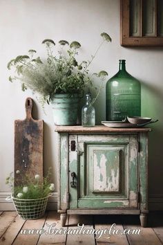 an old cabinet with some plants in it and a vase on the table next to it