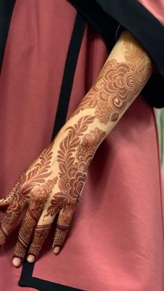 a woman's hand with henna tattoos on her left arm and the wrist