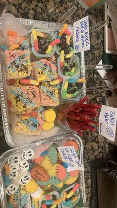 two plastic trays filled with different types of cookies and candies next to each other