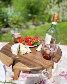 a wooden table topped with plates of food next to a bottle of wine and glasses