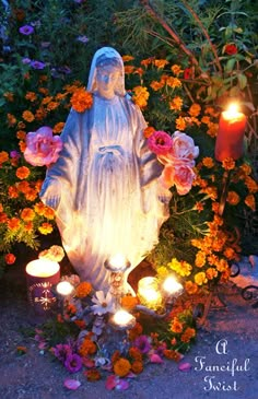 a statue surrounded by flowers and candles