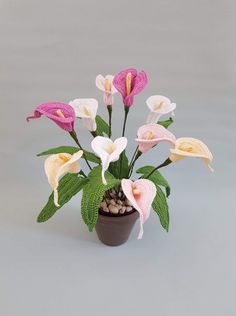 a potted plant with pink and white flowers in it's centerpiece on a grey background