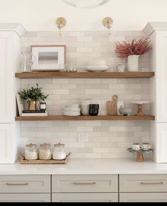 a kitchen with white cabinets and open shelves