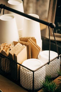 a basket filled with plates and cups on top of a table