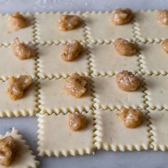 some ravioli with meatballs and sauce on them are arranged in the shape of squares