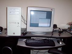 a computer monitor sitting on top of a desk next to a keyboard and mouse,