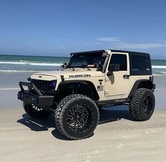 a white jeep is parked on the beach