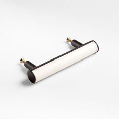 a white and black object on a white surface in the shape of a tube with two handles