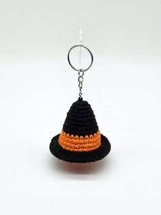 a crocheted keychain with a black and orange hat hanging from it