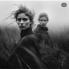 two women standing in tall grass looking at the camera