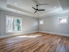 an empty room with hard wood floors and ceiling fan