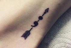 a small arrow tattoo on the ankle