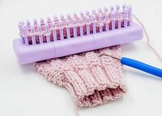 a close up of a pink and purple brush on top of a knitted cloth