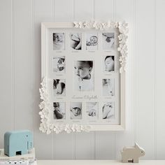 a baby's first year photo hanging on the wall next to a toy elephant