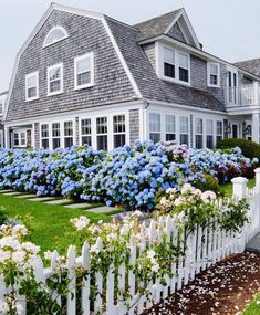 an instagram page with a house and flowers in the foreground, on which is also a white picket fence