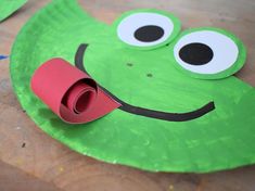 paper plate frog craft with googly eyes and tongue sticking out from it's mouth