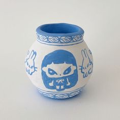 a blue and white vase with an image of a cat on the front is shown