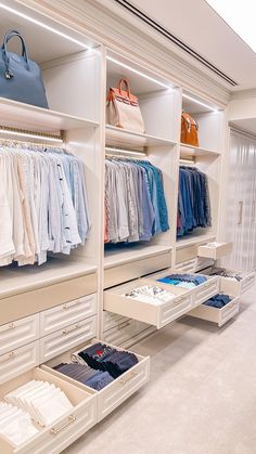 the closet is full of clothes and handbags on shelves, with drawers to hold items