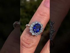 a woman's engagement ring with an oval blue sapphire surrounded by diamonds