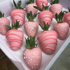 there are many strawberries with pink icing on them