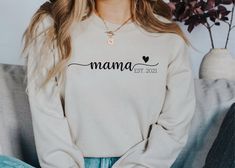 Mama(or your custom name) Est (your custom year) Unisex Sweatshirt Color pictured is a sand sweatshirt with black vinyl. Thank you for shopping Sweet Caroline Co! Please read full description for everything you need to know about ordering your new shirt. T-shirts are unisex and super soft Gildan Brand. Please see size chart before ordering. When in doubt, size up for room to grow and possible shrinking of fabric. Want a snugger fit? Shirts are unisex, so size down. Need a larger size than 2XL? I White Crew Neck Top With Custom Name, Custom Text Long Sleeve Tops For Gifts, Personalized Crew Neck Top, Personalized Long Sleeve Tops With Custom Text, Casual Custom Name Tops For Gifts, Casual Custom Name Top For Gift, Personalized Long Sleeve T-shirt With Letter Print, Customizable Long Sleeve T-shirt, Custom Name Casual Top For Gift