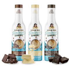 three bottles of sugar free syrups next to some chocolate and marshmallows