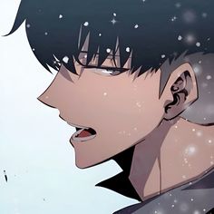 a man with black hair and glasses looking at something in the distance while snow falls on him