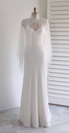 a white wedding dress on display in front of a window