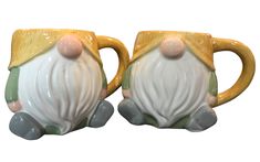 two ceramic mugs that have been decorated with santa claus's head and beard