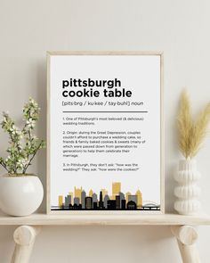 a poster with the words pittsburgh cookie table in black and white, on a shelf next to a potted plant