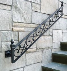 an iron stair rail on the side of a stone building