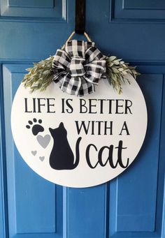 a sign that says life is better with a cat on it hanging from the front door