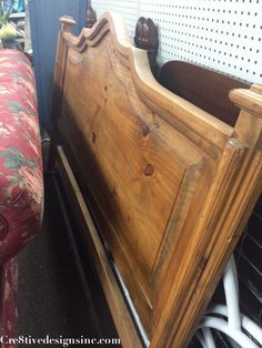 a wooden bed frame sitting next to a red couch