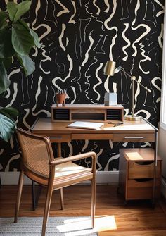 a desk with a chair next to it and a potted plant