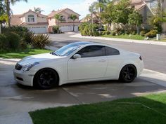 a white sports car parked in front of a house