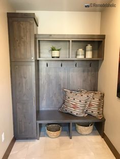 a wooden bench with two baskets on top of it next to a wall mounted shelf