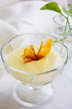 a small glass bowl filled with pudding on top of a white tablecloth covered table