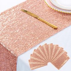 a table topped with pink and gold sequins next to a white plate covered in confetti