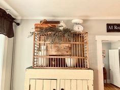 a birdcage filled with dishes on top of a dresser